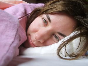 Žena, která leží v posteli s pneumokokem v nose